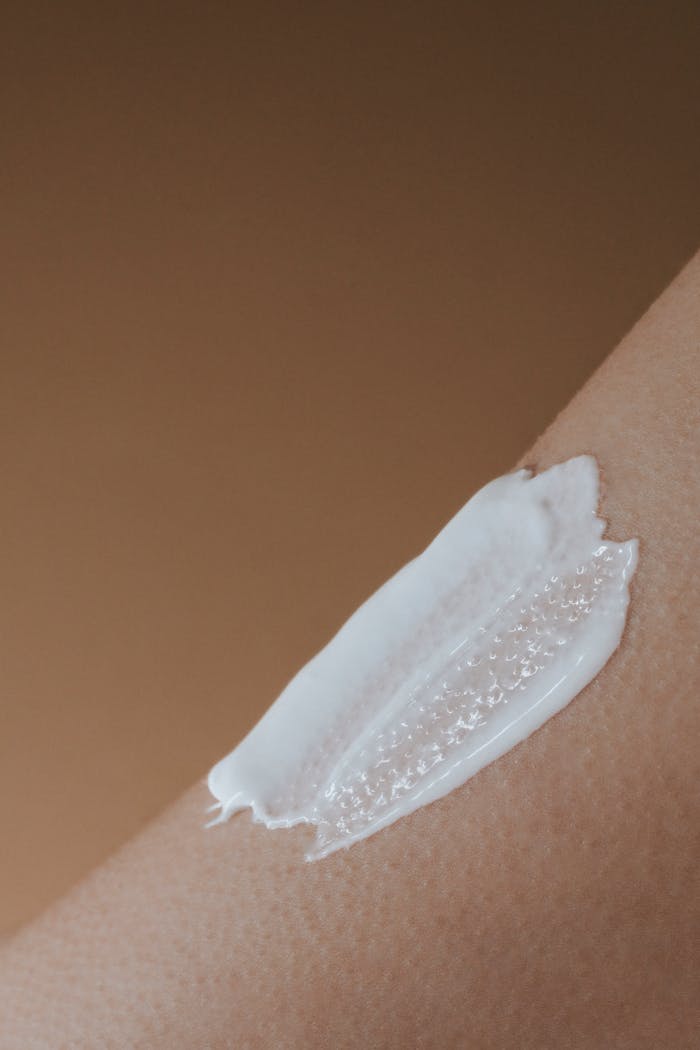 who-we-are A detailed view of moisturizing cream applied on smooth human skin.