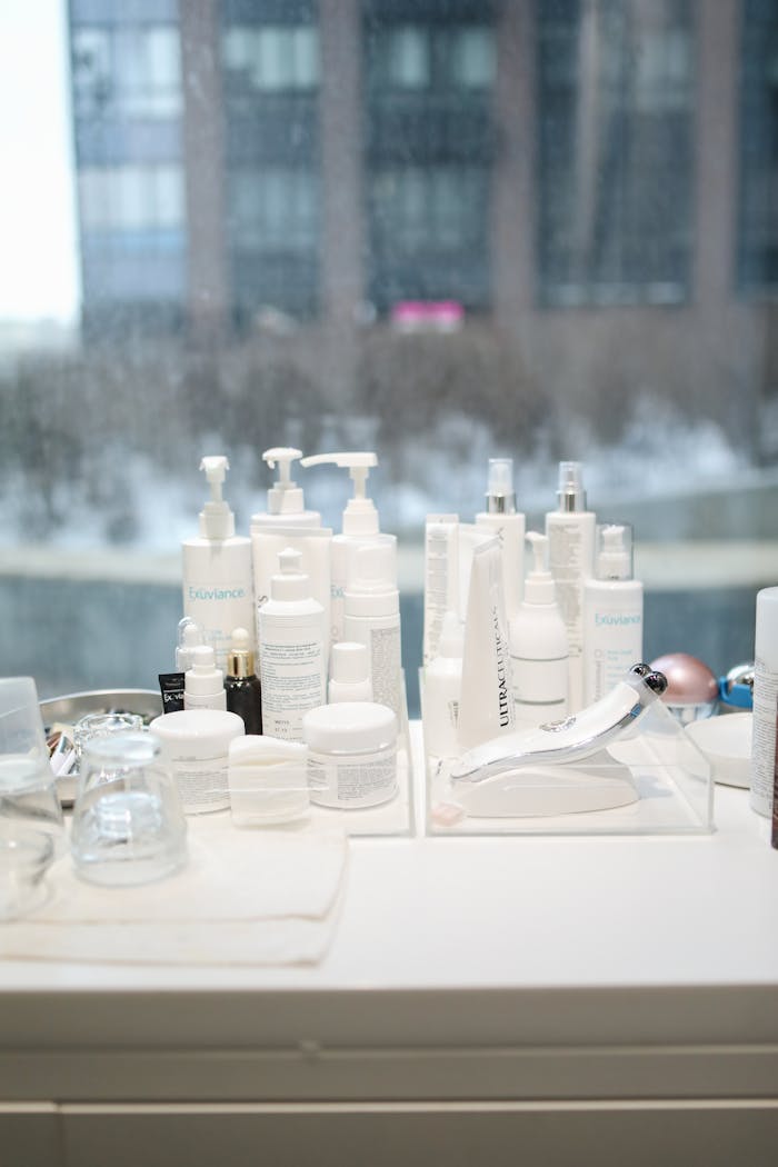 services-03 Skincare products arranged on a table by a window with a city view in the background.