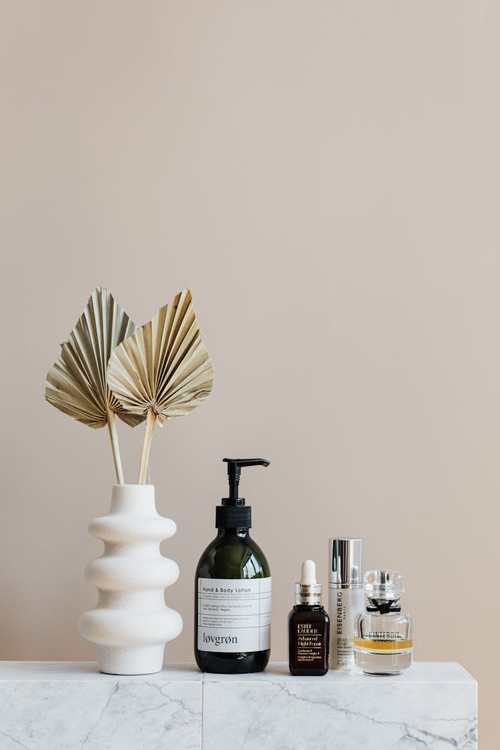 why-choose-us Minimalist bathroom shelf featuring skincare bottles and decorative beige vase.